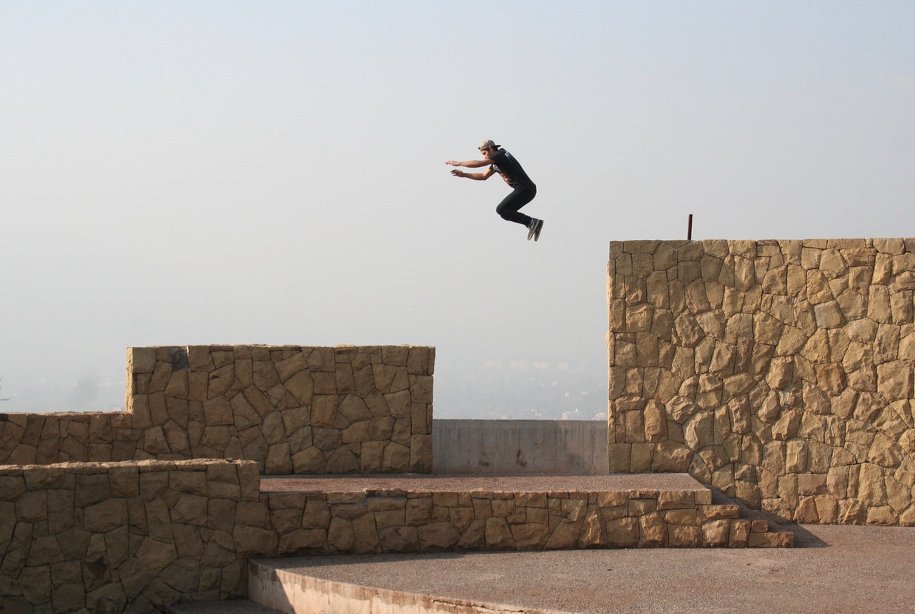 man jumping gap performing parkour