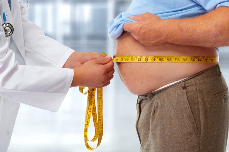 doctor measuring a patients waistline with visceral fat