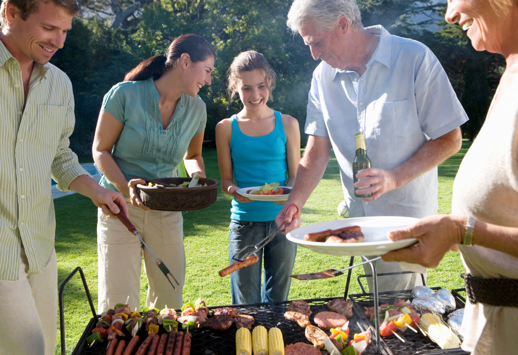 A family standing beside a barbecue grill