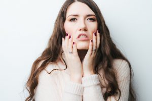 stressed woman touching her face