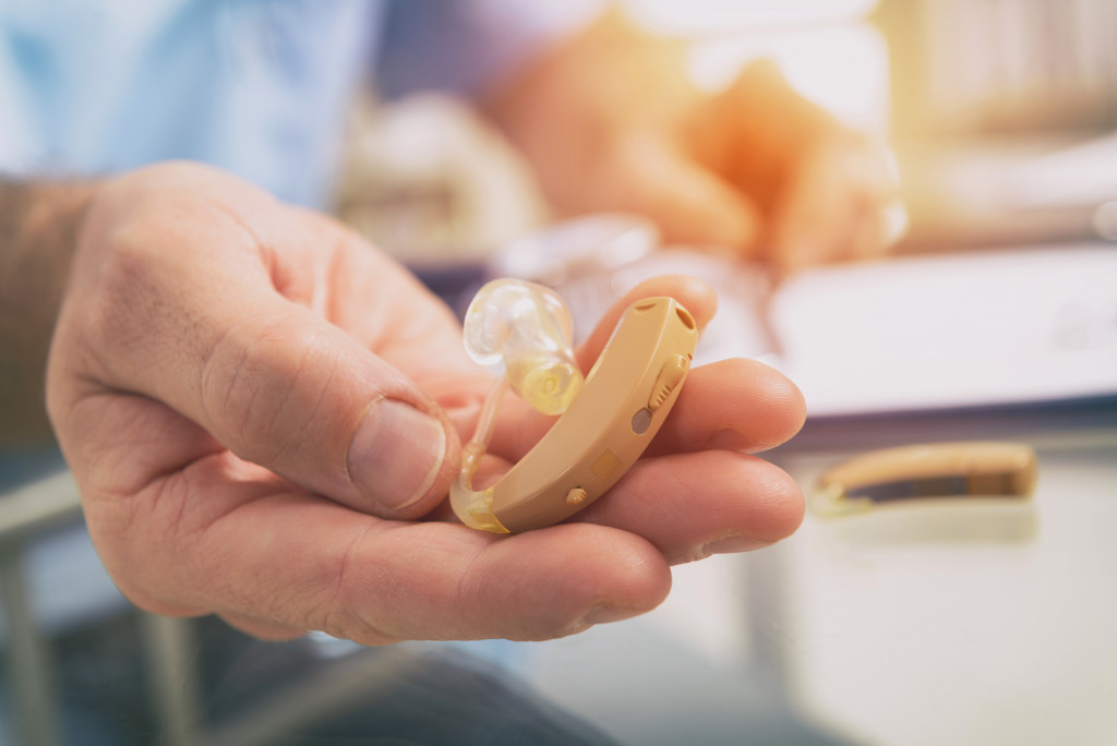 Focus on nurse's hands handing over a hearing aid