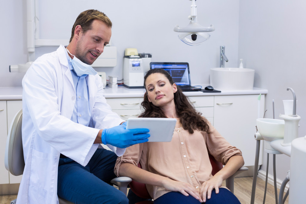 a male dentist is discussing a patient's dental health