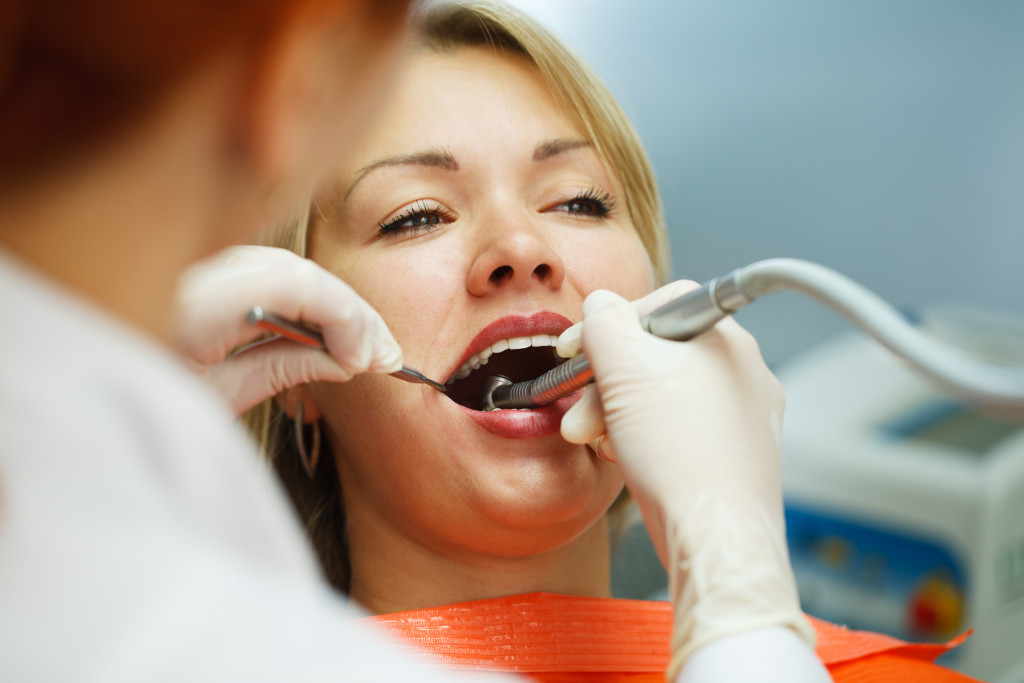 woman gets checkup at the dentist