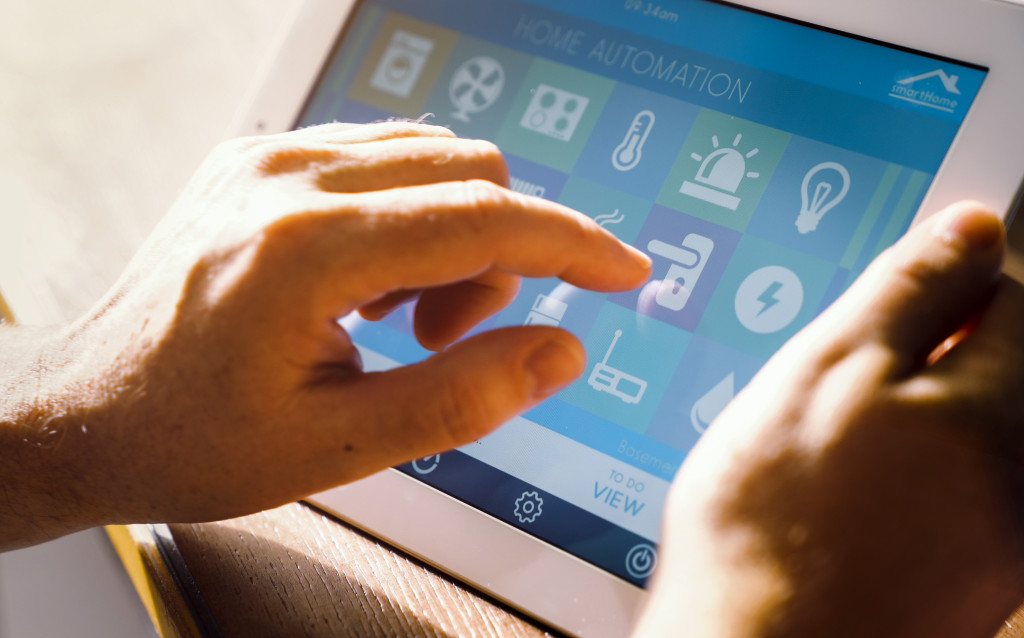 a man holding a tablet with smart home controls