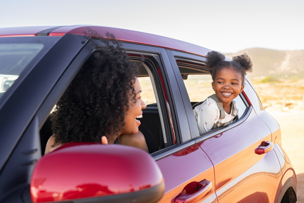 african american family on road trip in red car